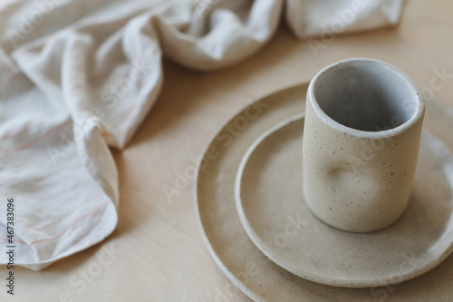 Beige ceramic plate on a wooden table top view. minimalist handmade ceramic tableware and pottery.