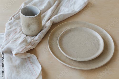Beige ceramic plate on a wooden table top view. minimalist handmade ceramic tableware and pottery.