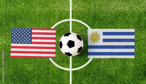 Top view soccer ball with USA vs. Uruguay flags match on green football field.