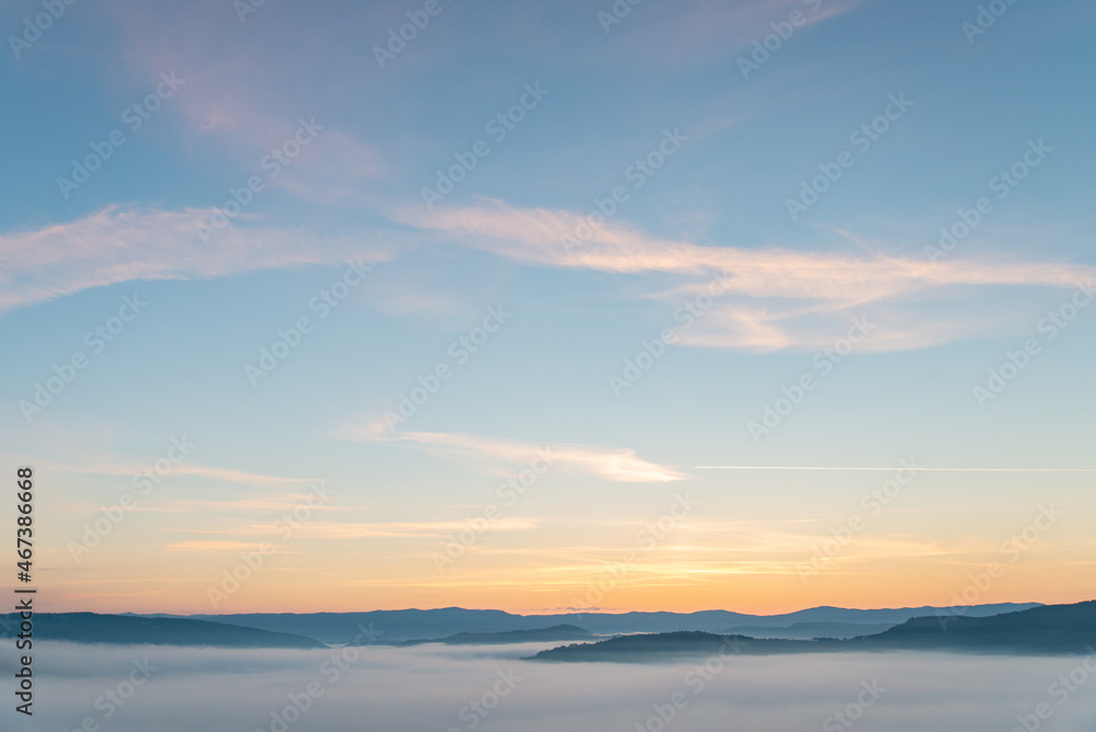 view of sunrise above mountains mist in the bottom