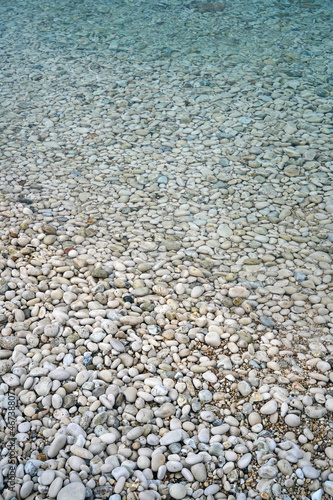 calm turquoise sea and pebbles beach background