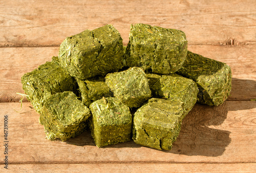 Foto Alfalfa-timothy cubes on a rustic wooden table