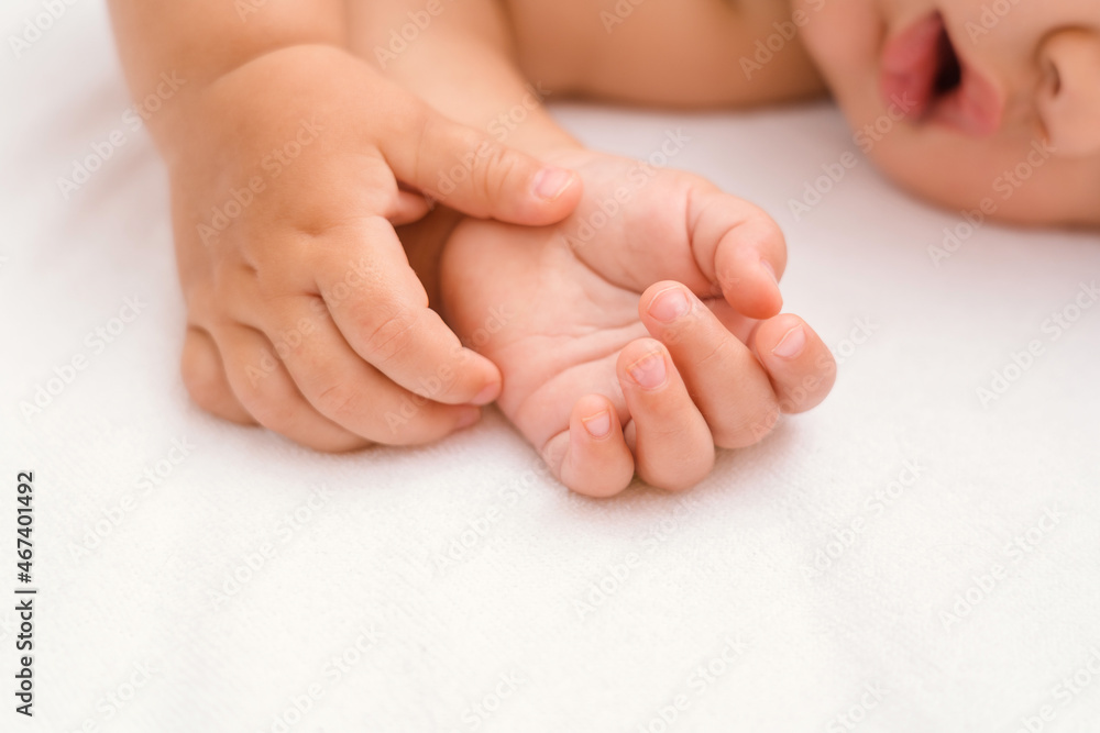 Hands of a sleeping baby close-up, selective focus on the palms of the child Hands of a sleeping baby close-up, selective focus on the palms of the child