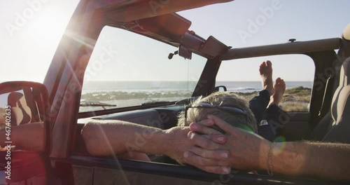 Wallpaper Mural Relaxed caucasian man lying in car resting on sunny day at the beach Torontodigital.ca