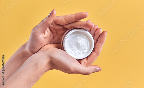 Skin care product. Close-up of women's hands holding a face cream jar. Beauty and spa product.