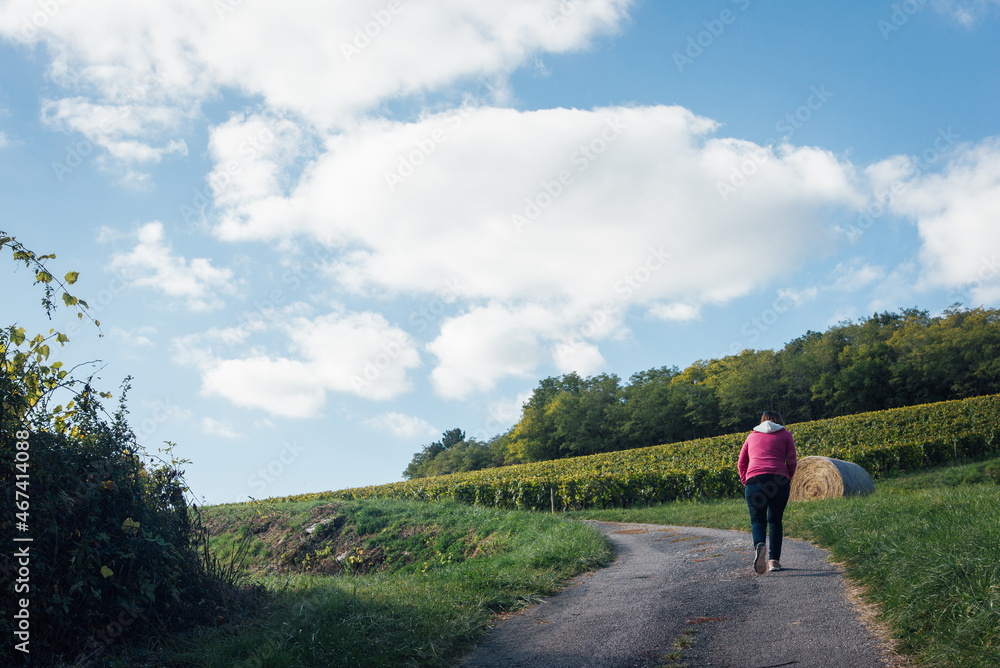 Une femme marchant sur une route de campagne. Une balade dans la campagne automnale.