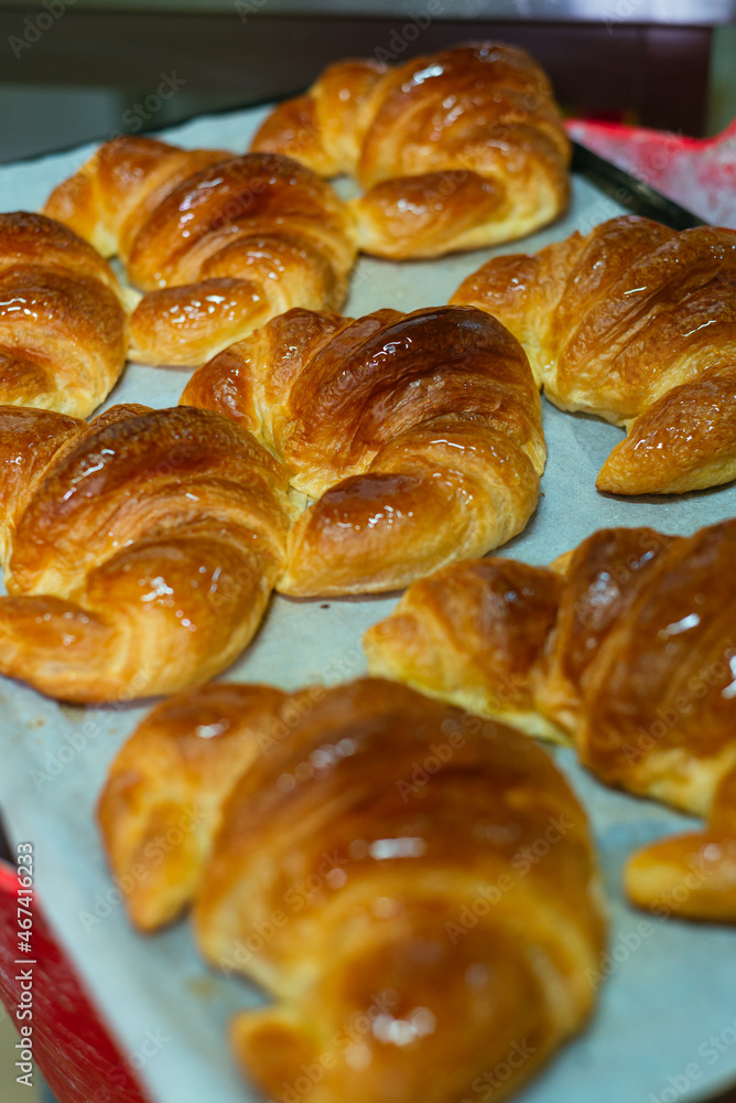 Fresh baked croissants placed on baking tray Fresh baked croissants placed on baking tray