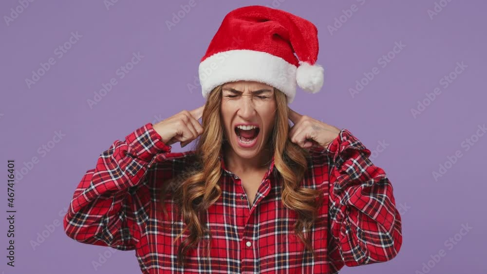 Mad displeased irritated sad angry young Santa woman wears shirt Christmas hat closed eyes cover ears do not want to listen scream isolated on plain pastel light violet background studio portrait Mad displeased irritated sad angry young Santa woman wears shirt Christmas hat closed eyes cover ears do not want to listen scream isolated on plain pastel light violet background studio portrait
