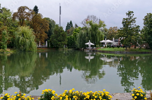 View of a cosy relaxation area under awnings with tables and chairs on the shores after rain of Lake Ariana, Borisova Gradina Park, Sofia, Bulgaria  photo