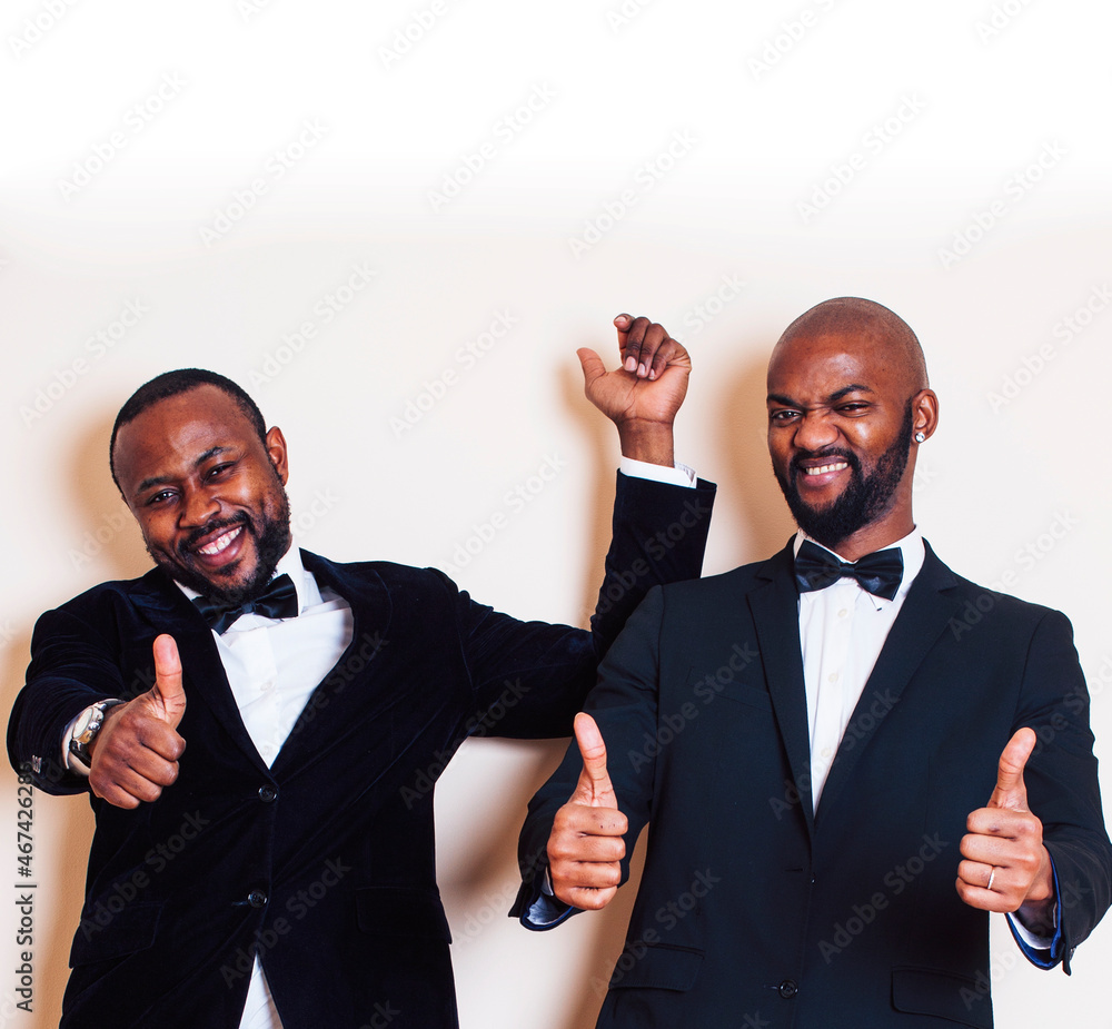 two afro-american businessmen in black suits emotional posing, gesturing, smiling. wearing bow-ties two afro-american businessmen in black suits emotional posing, gesturing, smiling. wearing bow-ties