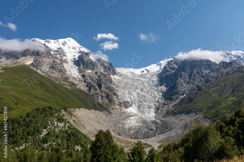 A panoramic view on the snow-capped peaks of Tetnuldi, Gistola, Lakutsia and the Adishi Glacier in the Greater Caucasus Mountain Range in Georgia, Svaneti Region. Sharp peaks, wanderlust, solitude.