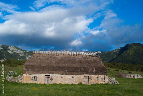 Traditional mountain house with stone walls and straw roof