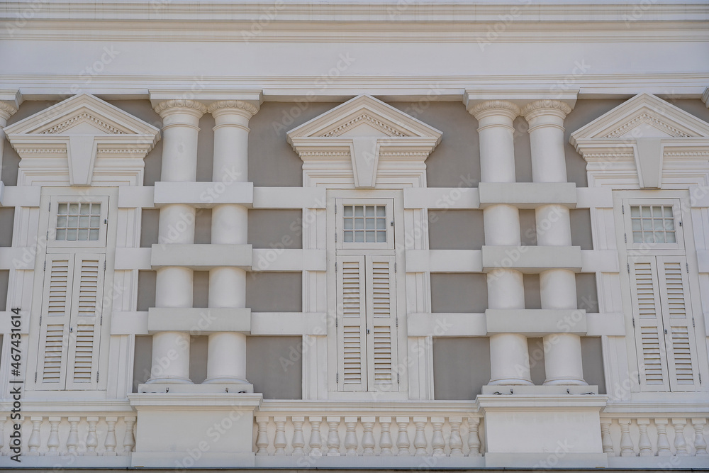 Obraz premium Window with white wooden shutters on wall building, Singapore
