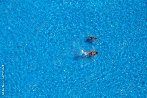 Two young girls swims in the swimming pool, view from above © OlegD