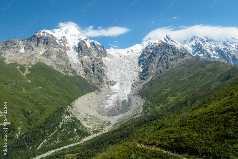 A panoramic view on the snow-capped peaks of Tetnuldi, Gistola, Lakutsia and the Adishi Glacier in the Greater Caucasus Mountain Range in Georgia, Svaneti Region. Sharp peaks, wanderlust, solitude.
