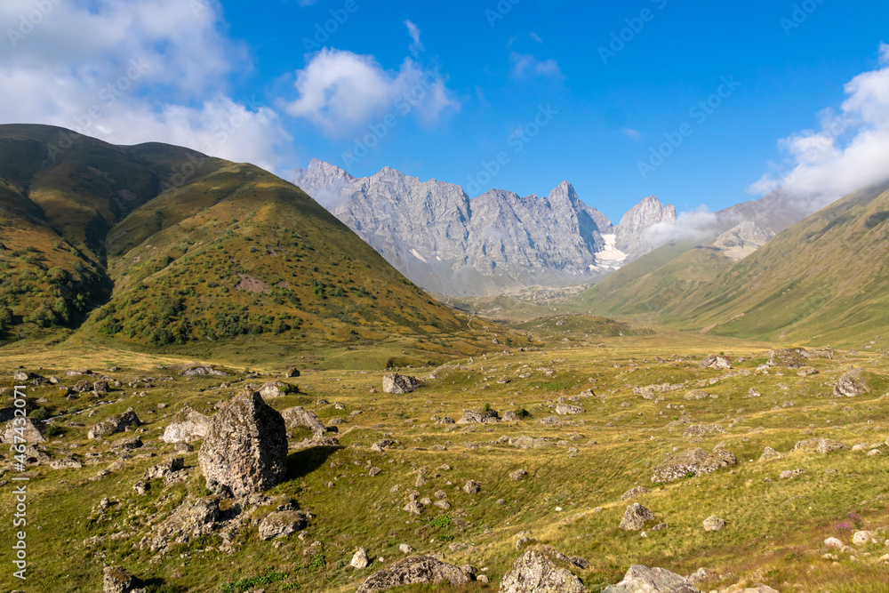 A panoramic view on the sharp mountain peaks of the Chaukhi massif in the Greater Caucasus Mountain Range in Georgia, Kazbegi Region. The valley is full of the Roshka stones. Georgian Dolimites.
