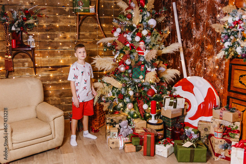 boy in red shorts near a Christmas tree