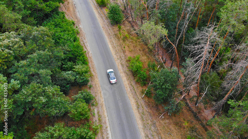 Aerial. Car driving at the asphalt country road. View above from drone.