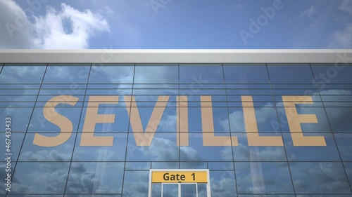 Airliner reflecting in the windows of airport terminal with SEVILLE text