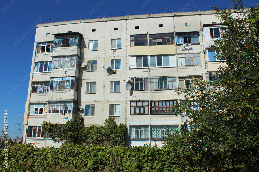 Fototapeta premium Multi-apartment five-story panel house, built in the USSR, a dormitory area of ​​the city in Ukraine in the summer, Eastern Europe. Topic rent, real estate, CIS country