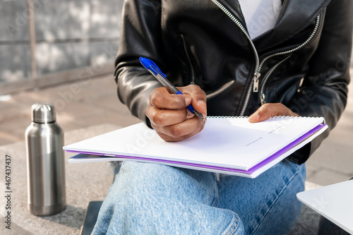 Anonymous black woman writing in notebook photo