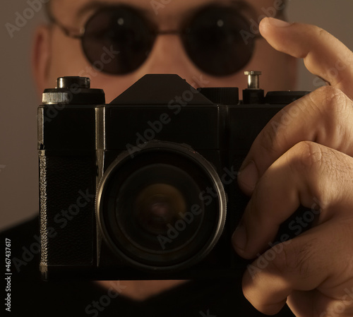 Man photographer with  photo camera with round  sunglasses. close up image. photo