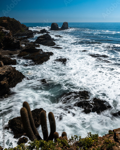 Vertical view of the coastline of punta de lobos beach with the waves crashing against the rocks on the shore.