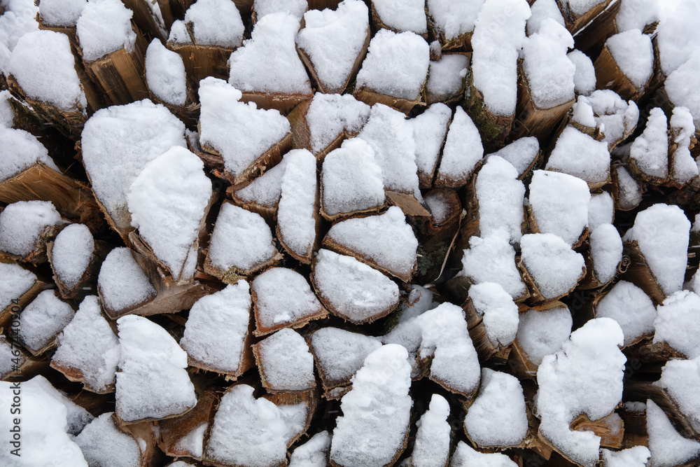 background of dry chopped firewood covered by snow and ice