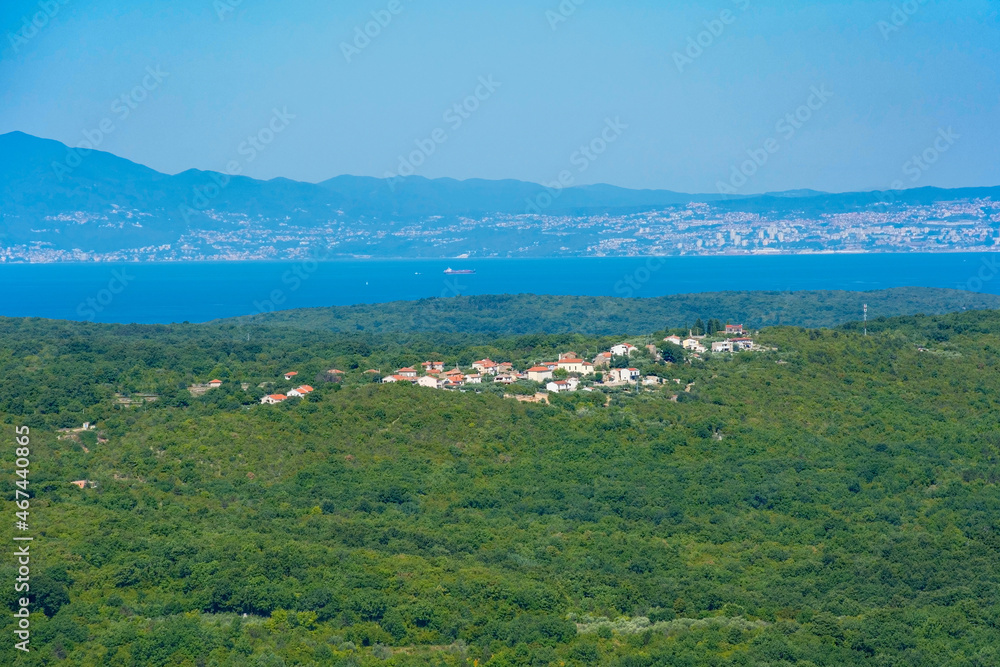 Landscape around the historic medieval hill village of Dobrinj on Krk island, Primorje-Gorski Kotar County, west Croatia. Suzan village is in the centre, Rijeka on the Croatian mainland in background Landscape around the historic medieval hill village of Dobrinj on Krk island, Primorje-Gorski Kotar County, west Croatia. Suzan village is in the centre, Rijeka on the Croatian mainland in background