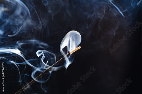 smoke from an aromatic stick on a black background.