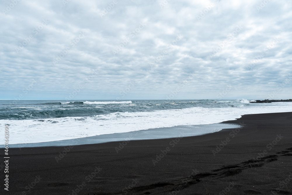 General view of Pichilemu on a cloudy day with its characteristic black sand.