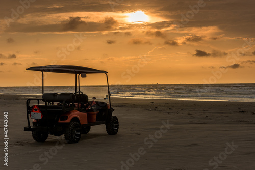 Golf cart parked on beach near sunset in Port Aransas, Texas photo