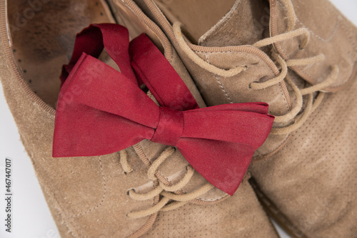 Groom accessories. Shoes on a white background with red butterfly suede shoes. View from above, bokeh.