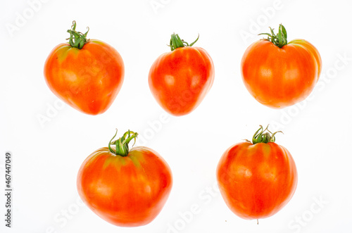 Red tomatoes in shape of heart on white background. Studio Photo