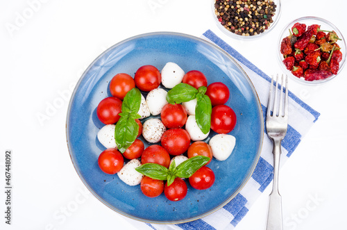 Vegetable salad with mozzarella balls on plate, white background. Studio Photo.