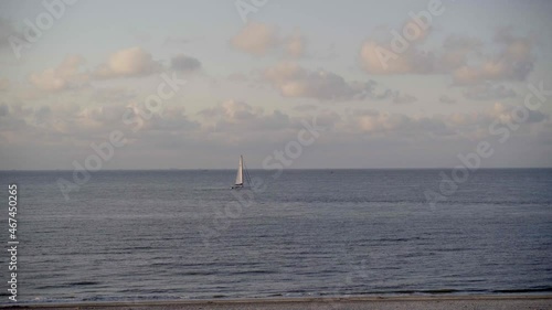 A sailboat out at sea sails by.