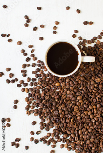 Fototapeta Naklejka Na Ścianę i Meble -  cup of aromatic coffee on a white background and scattered coffee grains. good morning . kind of sveru. flat lay. place for text. coffee time.
