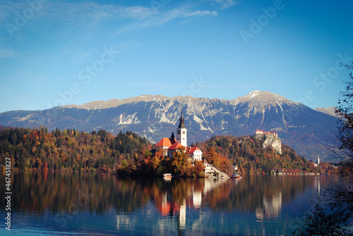 Famous alpine Bled lake in Slovenia, amazing autumn landscape. Scenic view of the lake, island with church, Bled castle, mountains and blue sky