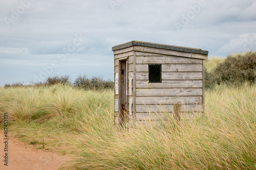 A wood hut for safety from high tides in a wild dune landscape on Spurn Point island photo