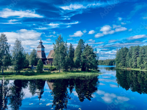landscape in finland with trees, lake and clouds