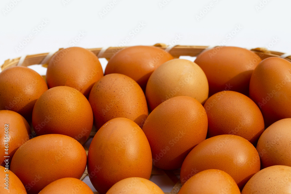 Chicken eggs in bamboo basket on white. Chicken eggs in bamboo basket on white.