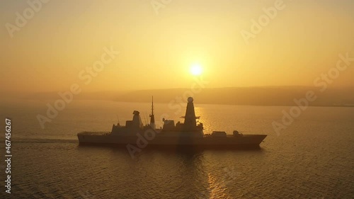 A modern air defence guided missile destroyer underway against the sun in mist photo