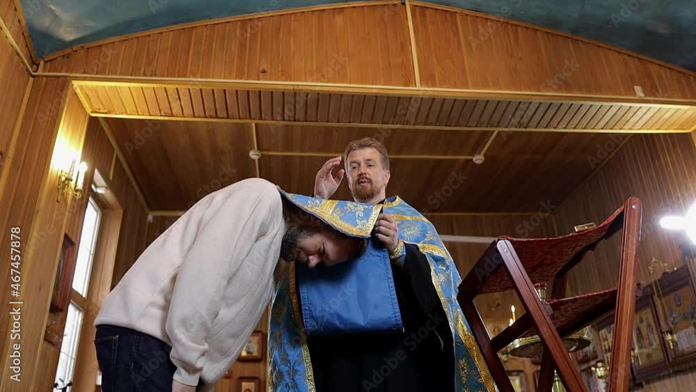 a man repents of his sins, confesses with a priest in the Orthodox church a man repents of his sins, confesses with a priest in the Orthodox church