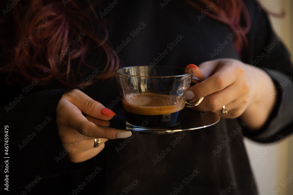in the girl's hands is a transparent cup of coffee in the girl's hands is a transparent cup of coffee