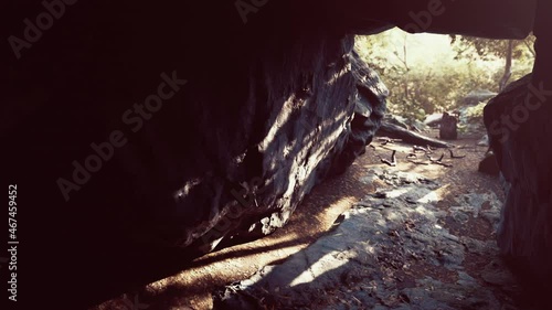 big dark cave and sun light from jungle forest photo