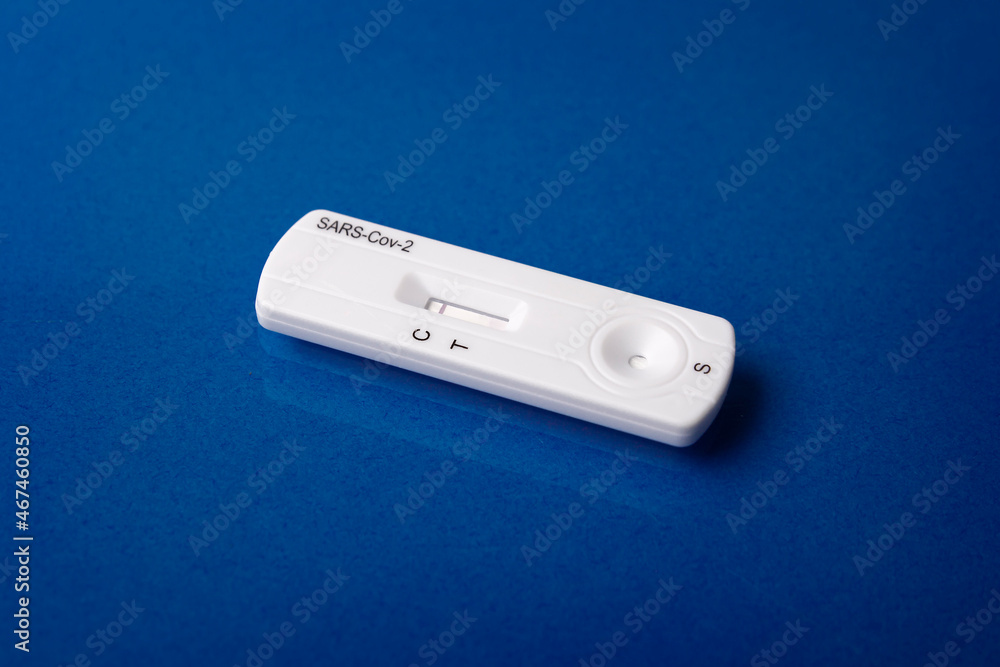 Close up image of Rapid test device for Covid-19 showing negative result. Lab card kit test for coronavirus SARS-CoV-2 virus. Fast test COVID-19 on purple surface