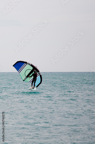 sportsman with wingfoil sailing, in the sea © Fernando