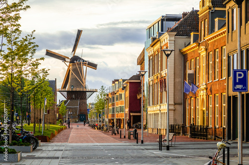Old wind mill and street with modern buildings, Delft, The Netherlands photo