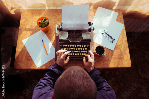 Male writer writing his book on an old antique typewriter. An old antique typewriter.