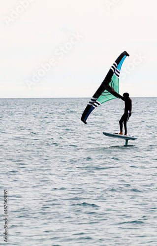 sportsman with wingfoil sailing, in the sea © Fernando
